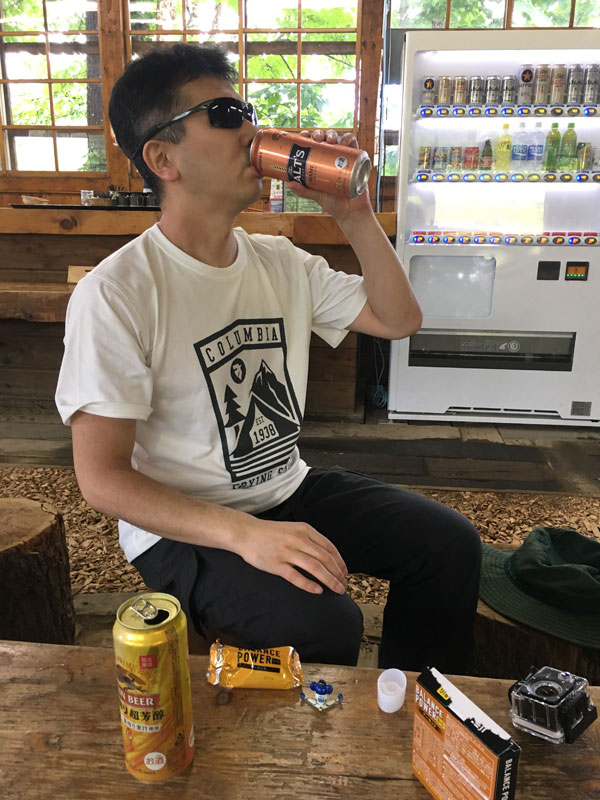 無料休憩小屋でビールを飲みながら雨が上がるのを待つ