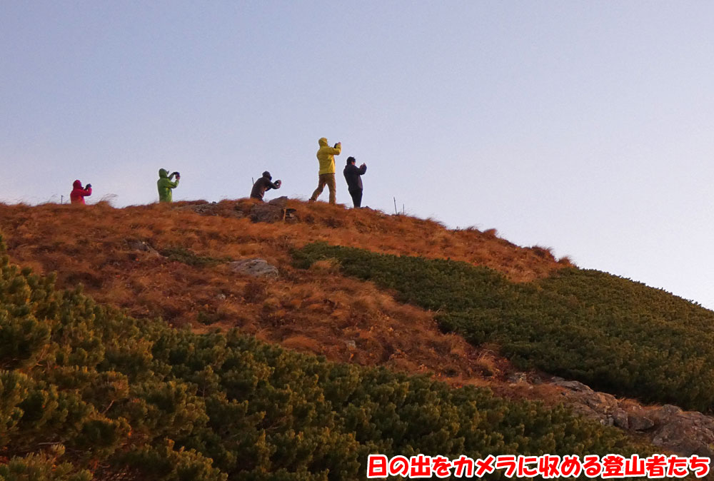 日の出をカメラに収める登山者たち